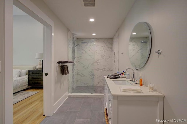 bathroom with visible vents, vanity, a marble finish shower, and recessed lighting