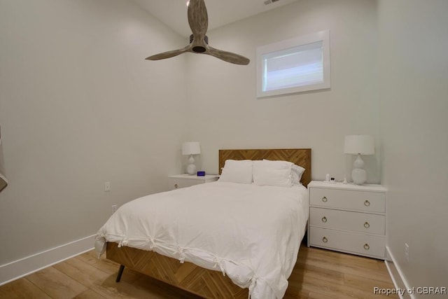 bedroom with light wood finished floors, baseboards, and ceiling fan