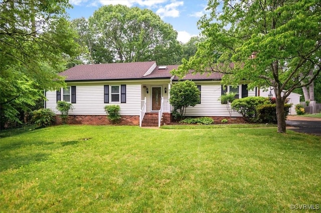 ranch-style home featuring a front lawn and a shingled roof