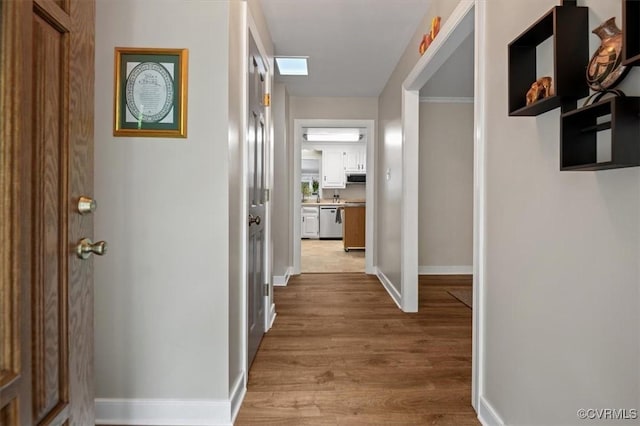 hallway with wood finished floors and baseboards