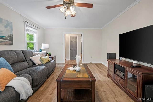 living room featuring light wood finished floors, crown molding, a ceiling fan, and baseboards