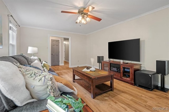 living room with light wood-style floors, ceiling fan, baseboards, and ornamental molding