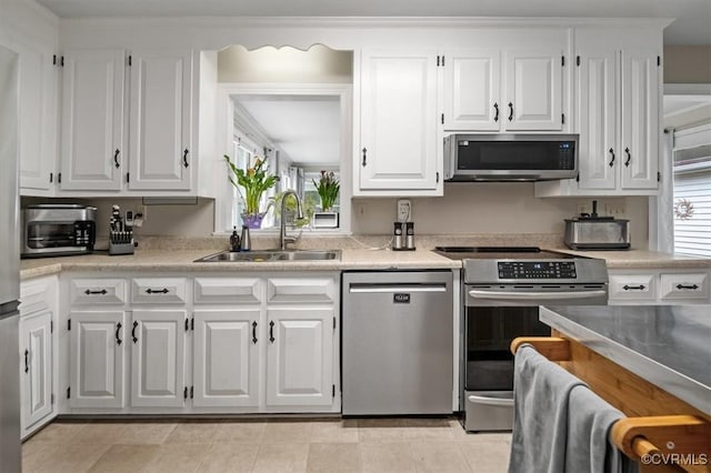 kitchen featuring stainless steel appliances, a sink, light countertops, and white cabinets