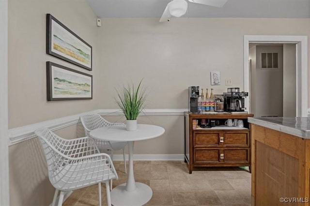 dining space with a ceiling fan and baseboards