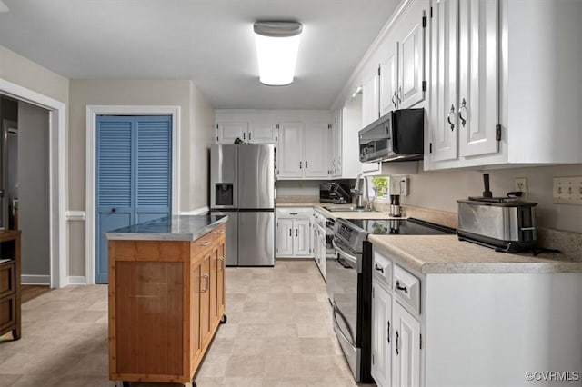 kitchen with stainless steel fridge, black electric range oven, a sink, white cabinets, and a center island