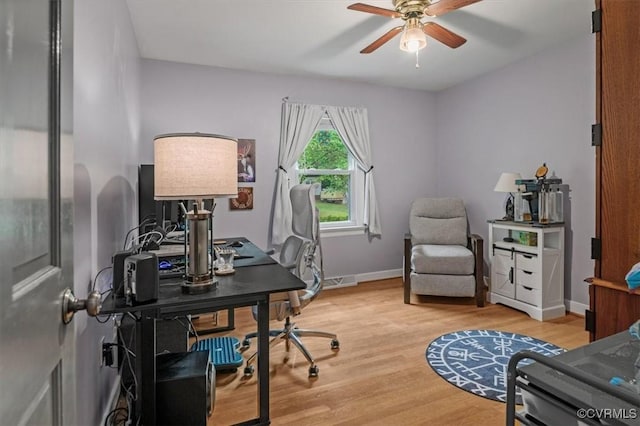 home office with wood finished floors, ceiling fan, and baseboards