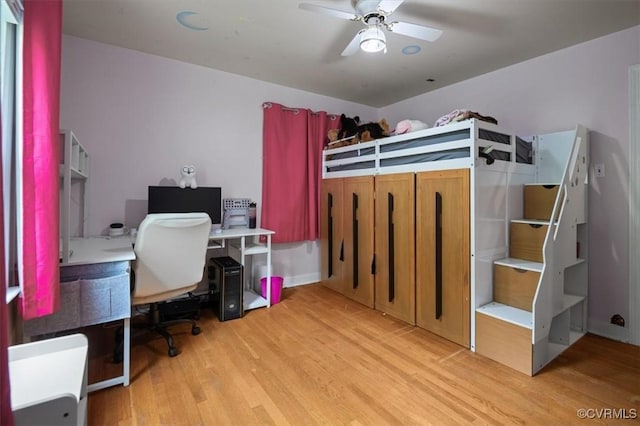bedroom with wood finished floors, an office area, and ceiling fan