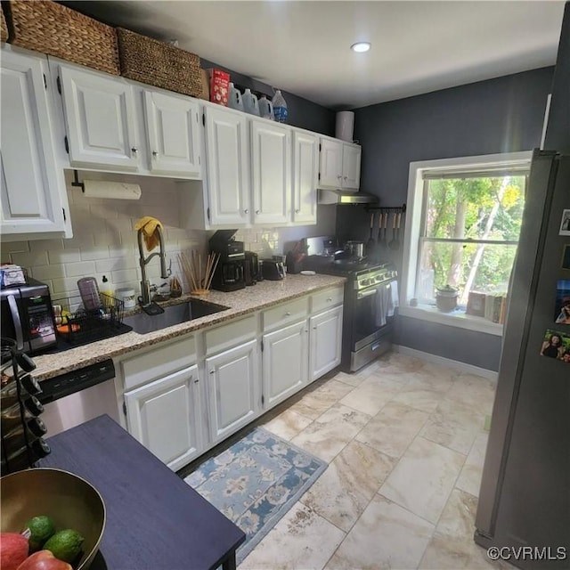 kitchen featuring a sink, white cabinetry, appliances with stainless steel finishes, and tasteful backsplash
