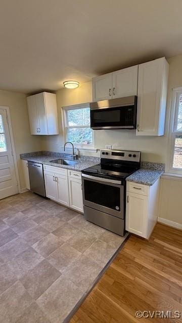 501 Faye St, Richmond, VA 23225 - kitchen featuring white cabinets, baseboards, appliances with stainless steel finishes, and a sink