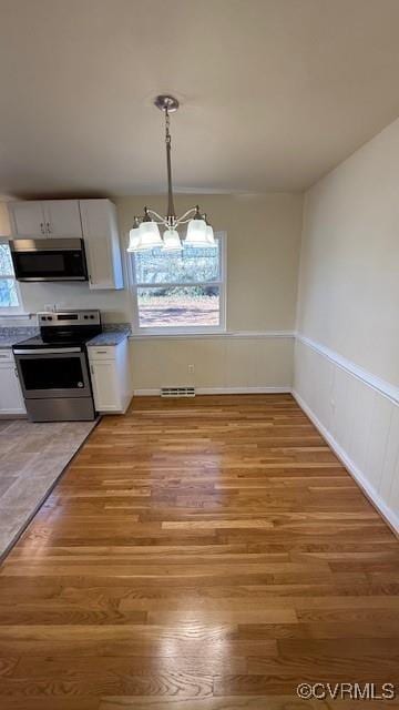 501 Faye St, Richmond, VA 23225 - unfurnished dining area with a chandelier and light wood-style floors