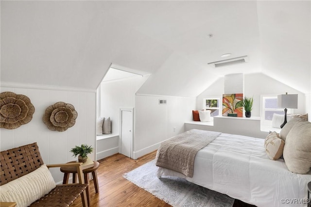 bedroom featuring visible vents, wood finished floors, and lofted ceiling