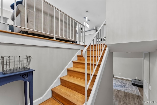 stairs with wood finished floors and baseboards