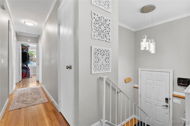 interior space featuring an upstairs landing, wood finished floors, ornamental molding, and baseboards