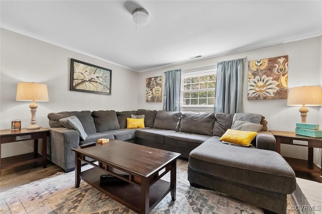 living room with visible vents, ornamental molding, and wood finished floors