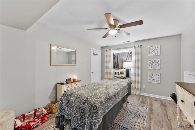 bedroom featuring visible vents, ceiling fan, light wood-style flooring, and baseboards