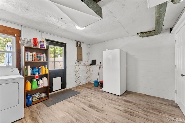 interior space featuring a healthy amount of sunlight, washer / dryer, electric panel, and freestanding refrigerator
