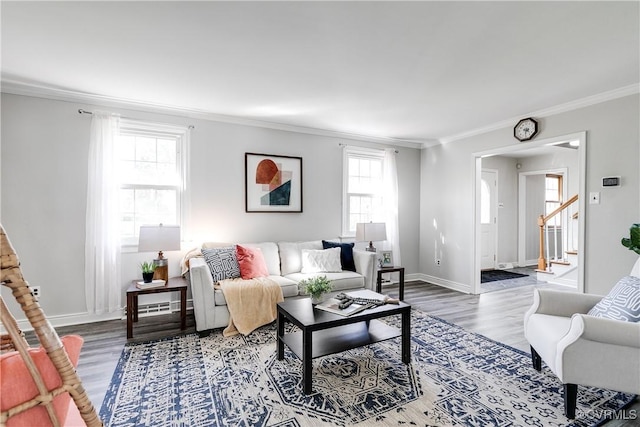 living area with stairway, baseboards, ornamental molding, and wood finished floors