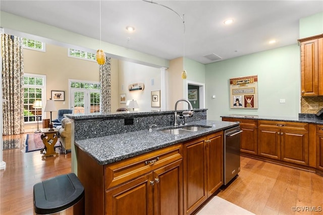 9522 Nassington Ct, Henrico, VA 23229 - kitchen featuring a sink, light wood finished floors, stainless steel dishwasher, a kitchen island with sink, and dark stone countertops