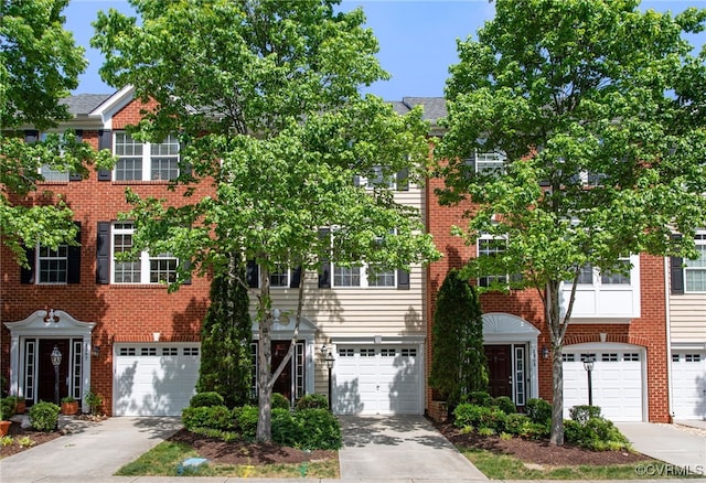 view of property featuring an attached garage, driveway, and brick siding