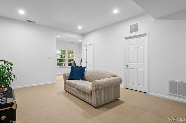 sitting room featuring visible vents, baseboards, and light colored carpet