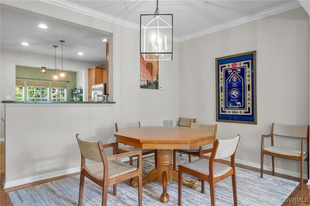 dining space with baseboards, a chandelier, wood finished floors, and visible vents