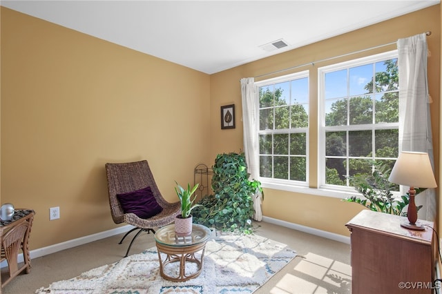sitting room featuring visible vents, baseboards, and light colored carpet