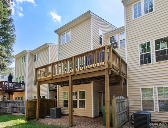 back of property featuring fence, cooling unit, and a wooden deck