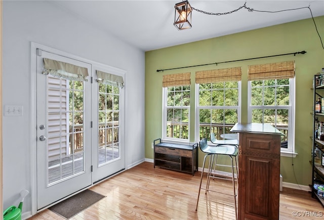 doorway to outside with baseboards and light wood-type flooring
