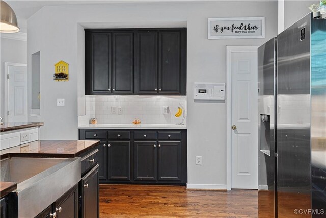 kitchen with dark wood-type flooring, tasteful backsplash, and dark cabinetry