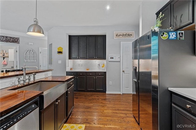 kitchen featuring decorative backsplash, appliances with stainless steel finishes, a sink, dark wood-style floors, and pendant lighting