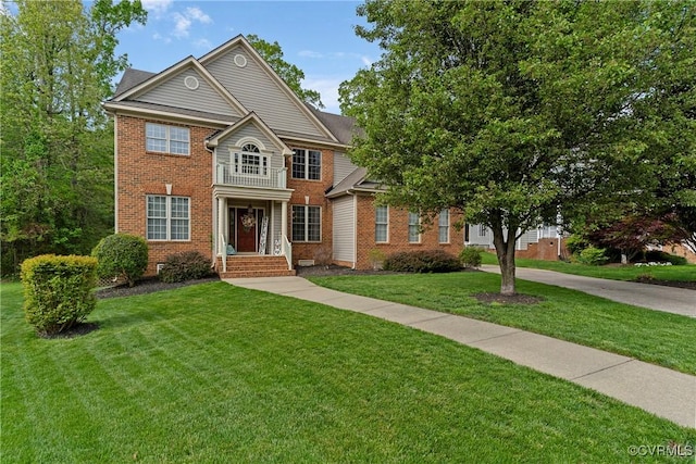 colonial inspired home featuring brick siding and a front lawn