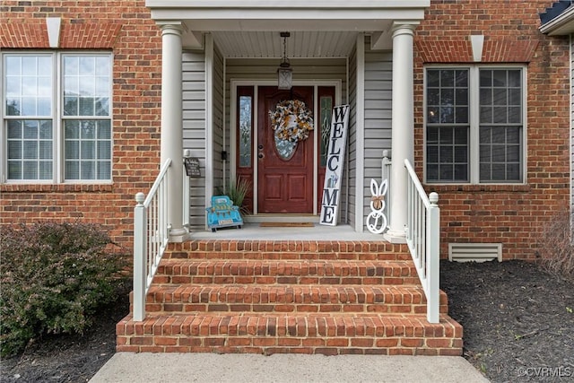 entrance to property featuring brick siding