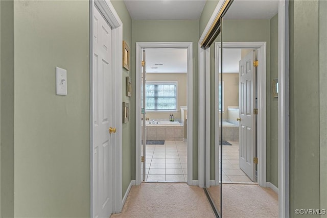hall with baseboards and light tile patterned floors