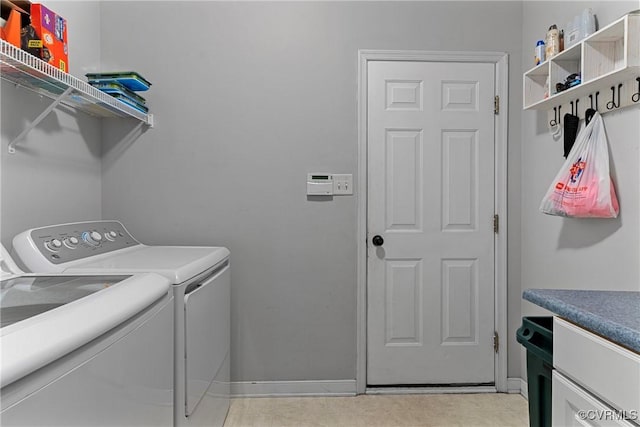laundry room featuring baseboards, separate washer and dryer, and laundry area