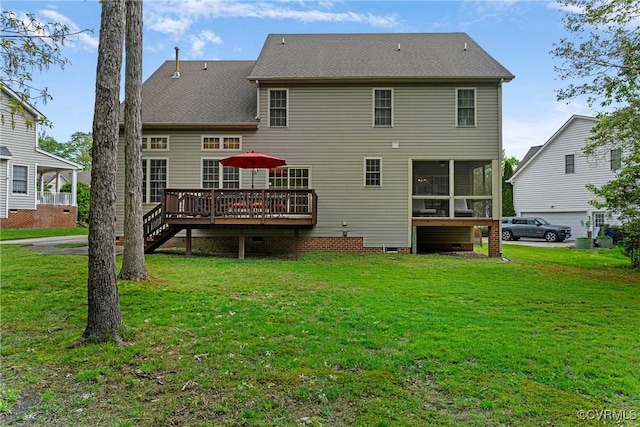 rear view of property with a yard, crawl space, a wooden deck, and a sunroom