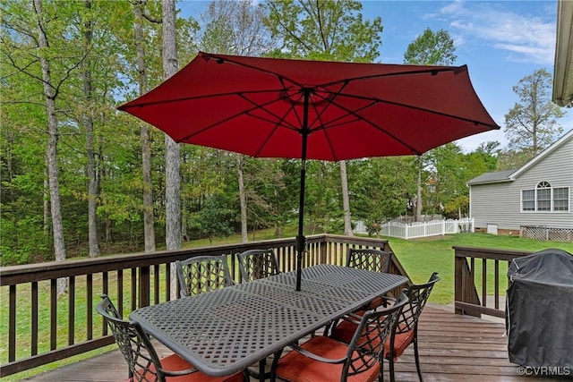 wooden deck featuring a lawn, outdoor dining space, grilling area, and fence