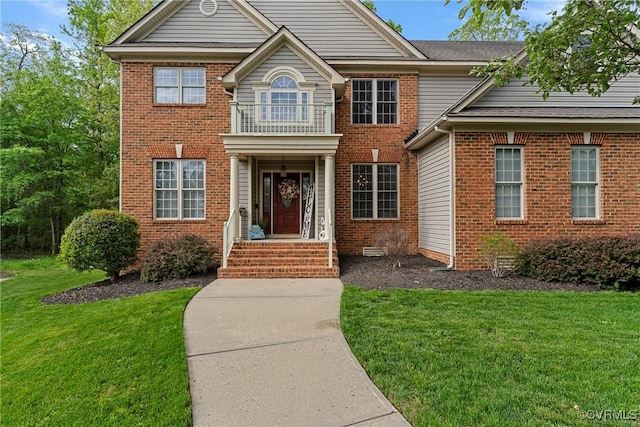 colonial house featuring brick siding and a front lawn