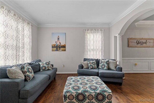 living room featuring crown molding, arched walkways, decorative columns, and wood finished floors