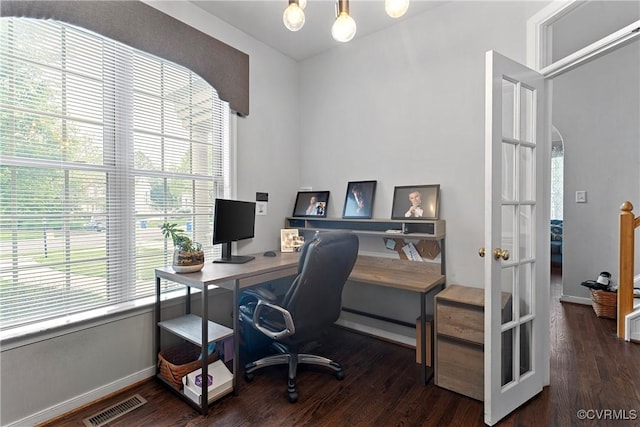 home office with a baseboard heating unit, visible vents, a wealth of natural light, and wood finished floors