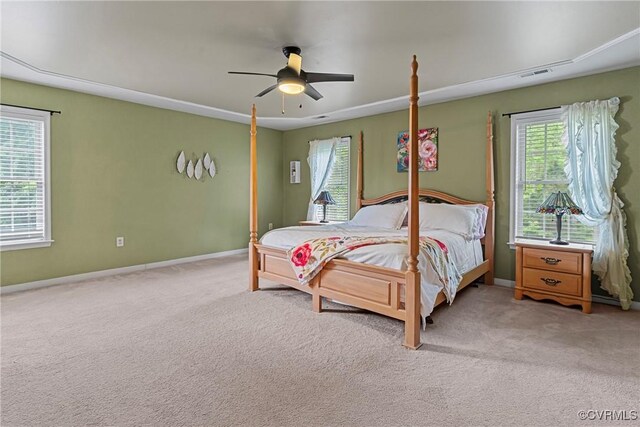 bedroom featuring baseboards, visible vents, light carpet, and multiple windows