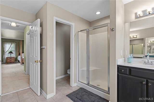 ensuite bathroom featuring a shower stall, vanity, toilet, tile patterned flooring, and ensuite bathroom