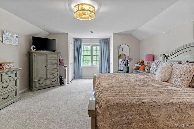 bedroom featuring lofted ceiling, baseboards, and light carpet