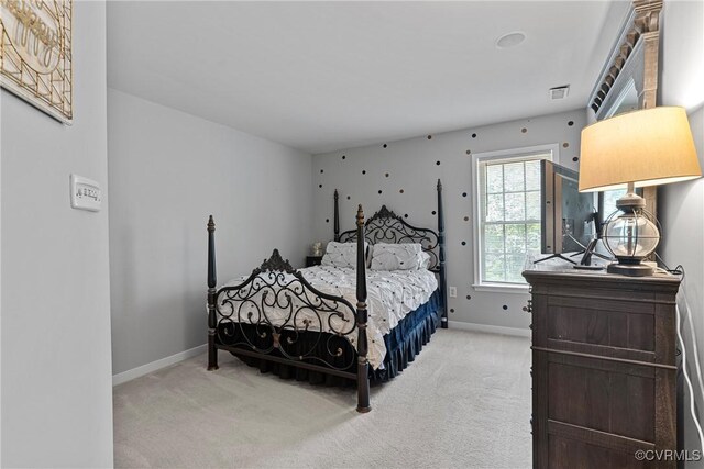 bedroom featuring baseboards, visible vents, and light carpet