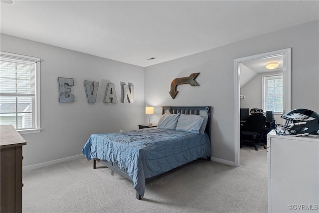 bedroom with baseboards, multiple windows, and light colored carpet