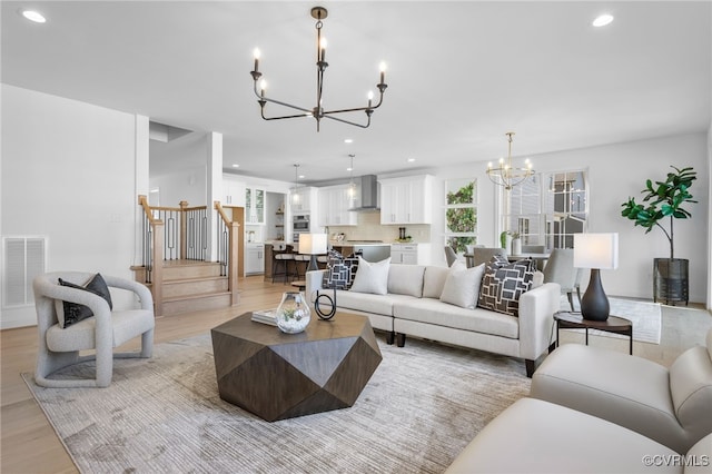 living area with recessed lighting, light wood finished floors, stairway, a chandelier, and visible vents