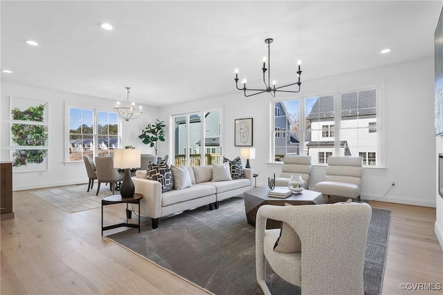 living area featuring recessed lighting, a notable chandelier, wood finished floors, and baseboards