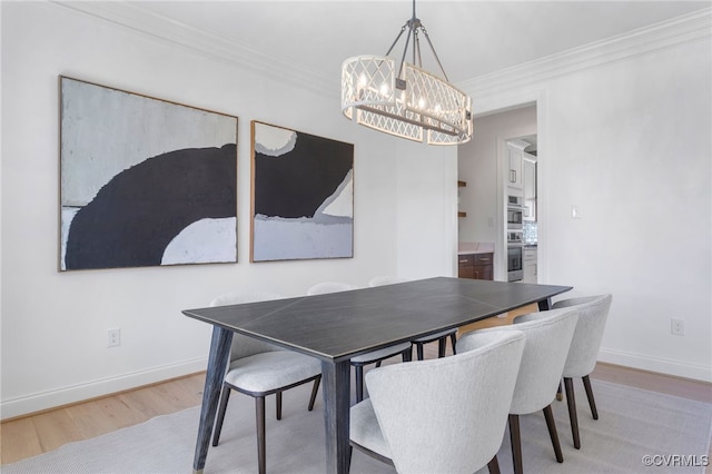 dining area with baseboards, light wood-type flooring, an inviting chandelier, and crown molding