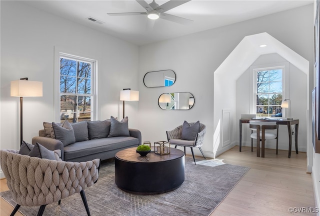 living room featuring visible vents, a ceiling fan, light wood finished floors, and baseboards