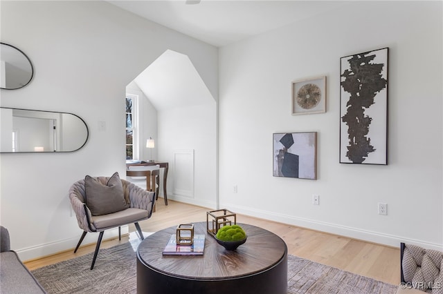 living area featuring baseboards and light wood-type flooring