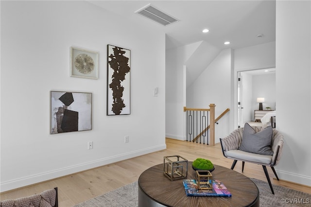 sitting room featuring an upstairs landing, visible vents, baseboards, recessed lighting, and wood finished floors